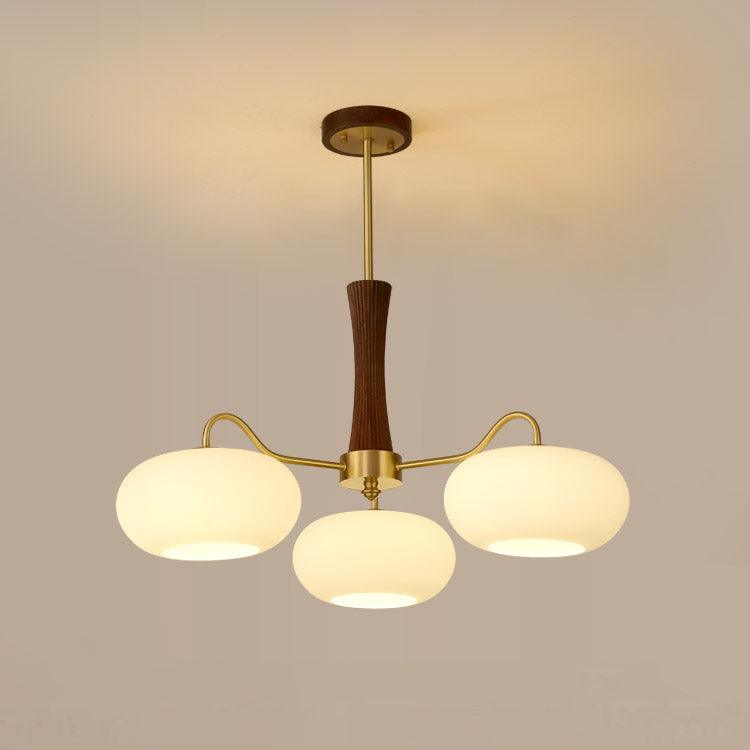 Persimmon chandelier detail showing brass arm and glass shade