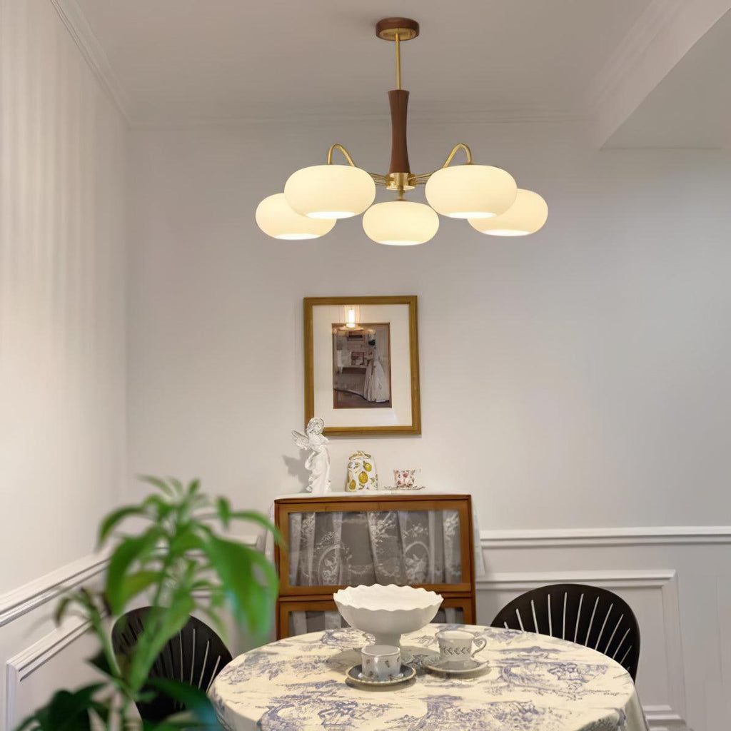 Brass chandelier with white glass shades and wood detailing