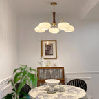 Brass chandelier with white glass shades and wood detailing