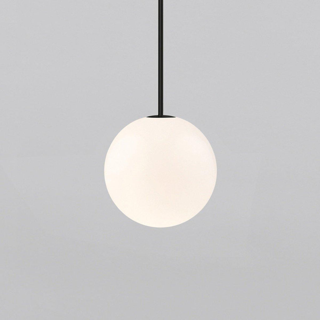 White opal glass globe pendant glowing with warm even light