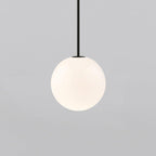 White opal glass globe pendant glowing with warm even light