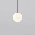 White opal glass globe pendant light on a slim brass rod