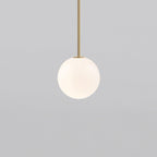White opal glass globe pendant light on a slim brass rod