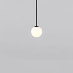 Opal glass globe pendant light suspended on a minimal brass rod