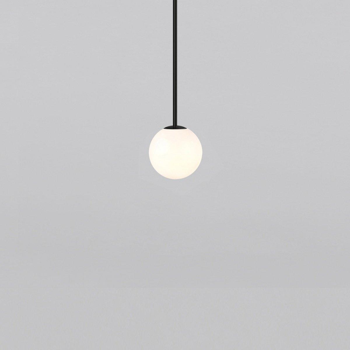 Opal glass globe pendant light suspended on a minimal brass rod