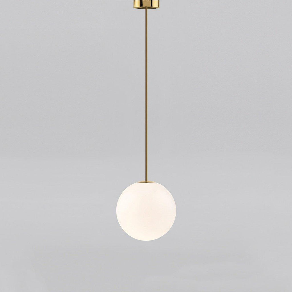 White opal glass globe pendant glowing in a dim room