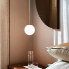 Opal glass globe pendant glowing warmly above a seating area