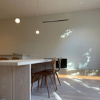 White opal glass globe pendant with brass rod in an interior