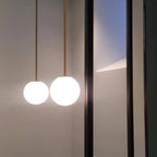 Opal glass globe pendant light shown over a dining table
