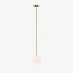 White opal glass globe pendant glowing against a neutral wall