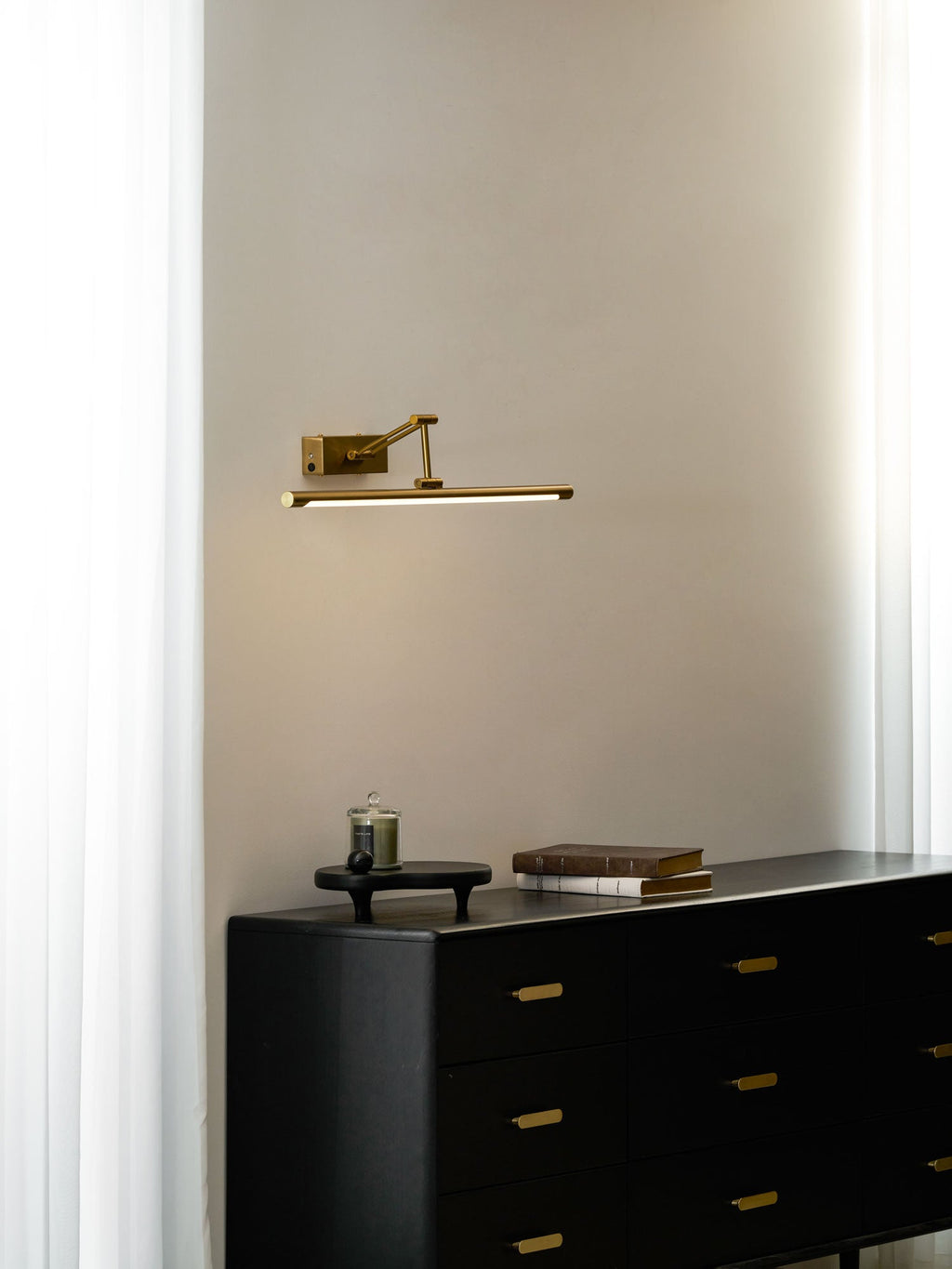 Rechargeable gold picture light glowing softly above framed art