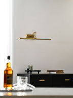 Rechargeable picture light in gold shown over a wall-mounted canvas
