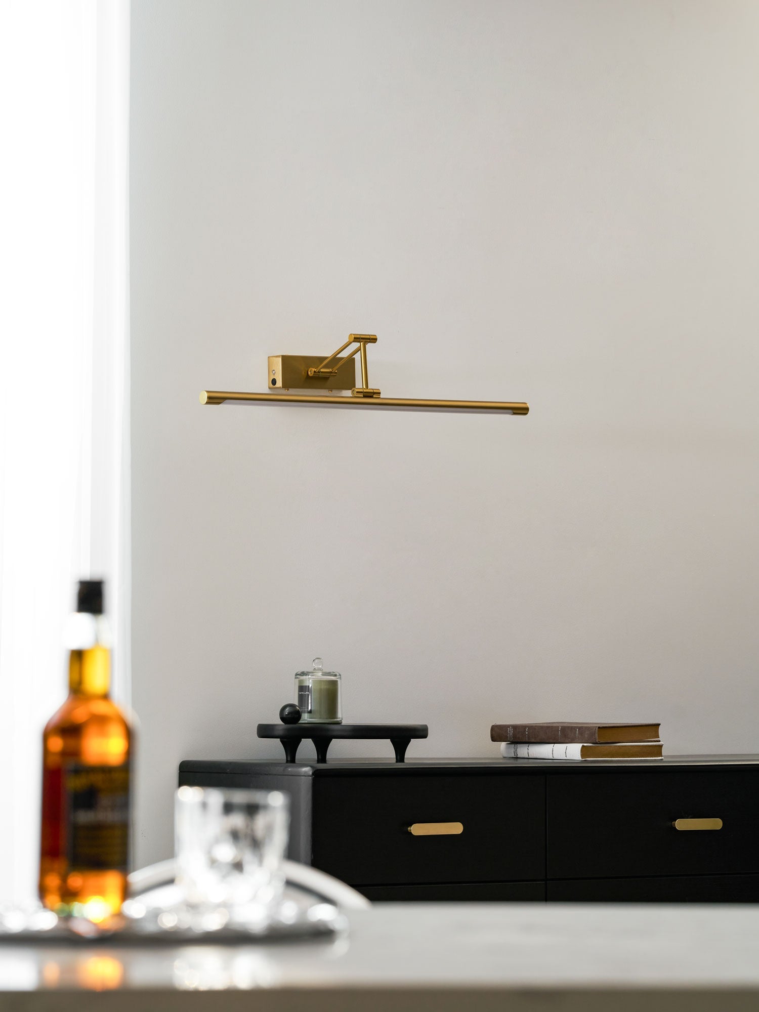 Rechargeable picture light in gold shown over a wall-mounted canvas