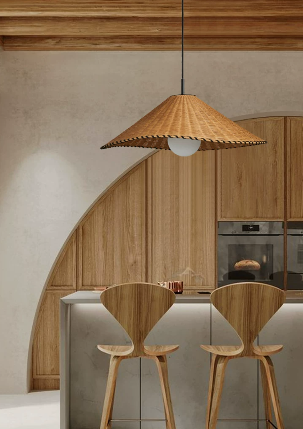 Beneath a curved archway, this lit Clérachic pendant hangs above a wood kitchen island with bar stools.