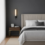 Brass wall sconce mounted on a wall with glowing alabaster shade