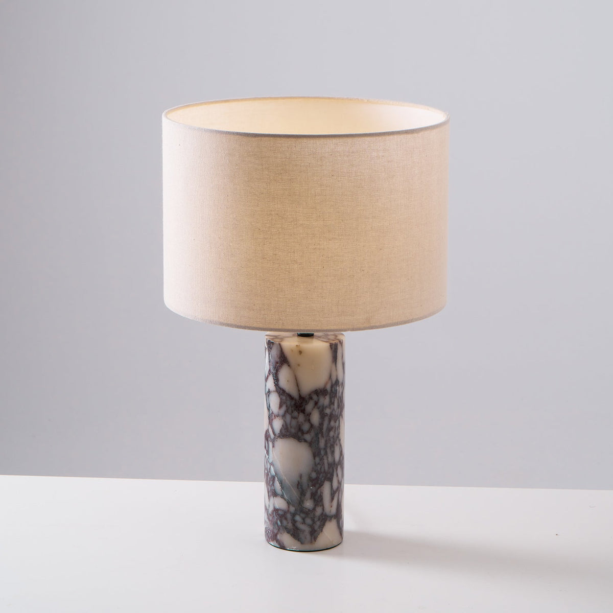 A taller crop shows more of the column base on this Clérachic marble lamp, set against plain grey.