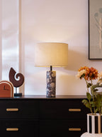 The widest view here places the Clérachic marble lamp on its dark sideboard, framed art and flowers filling the room.