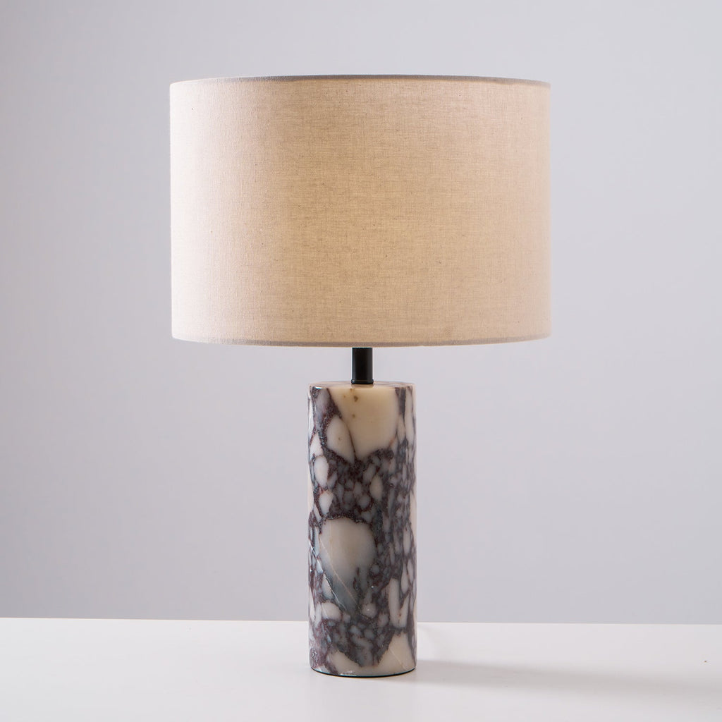 Clérachic marble table lamp shot front-on against grey, the full column base and drum shade centred in frame.