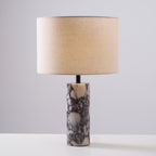 Clérachic marble table lamp shot front-on against grey, the full column base and drum shade centred in frame.