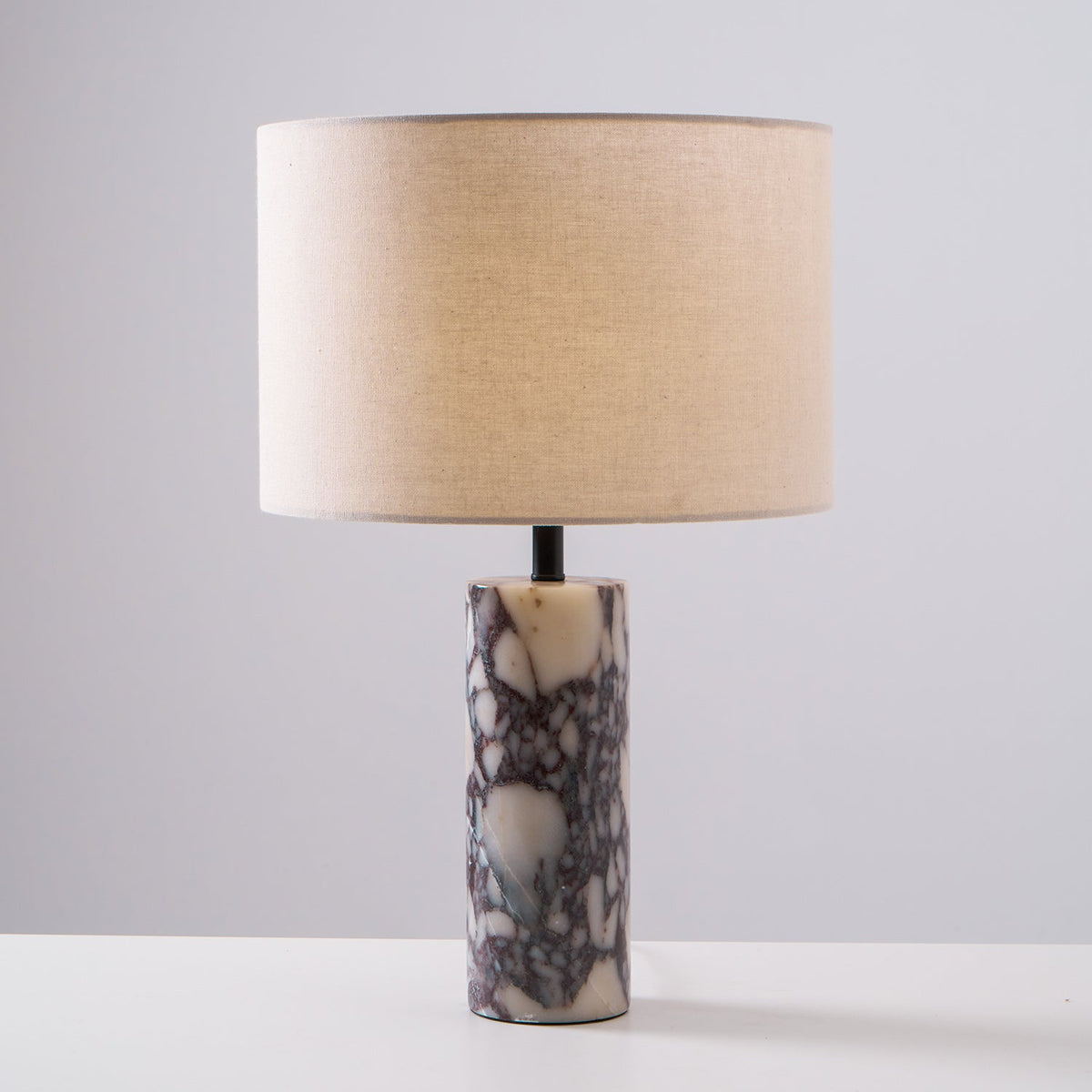 Clérachic marble table lamp shot front-on against grey, the full column base and drum shade centred in frame.
