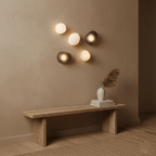 Hand-blown glass wall lamp glowing beside a styled setting