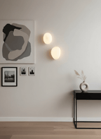 Hand-blown glass wall lamp with a rounded translucent shade