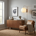 Round white wall sconce glowing in a dim styled living space