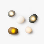 Pebble glass wall lamp glowing softly in a modern interior