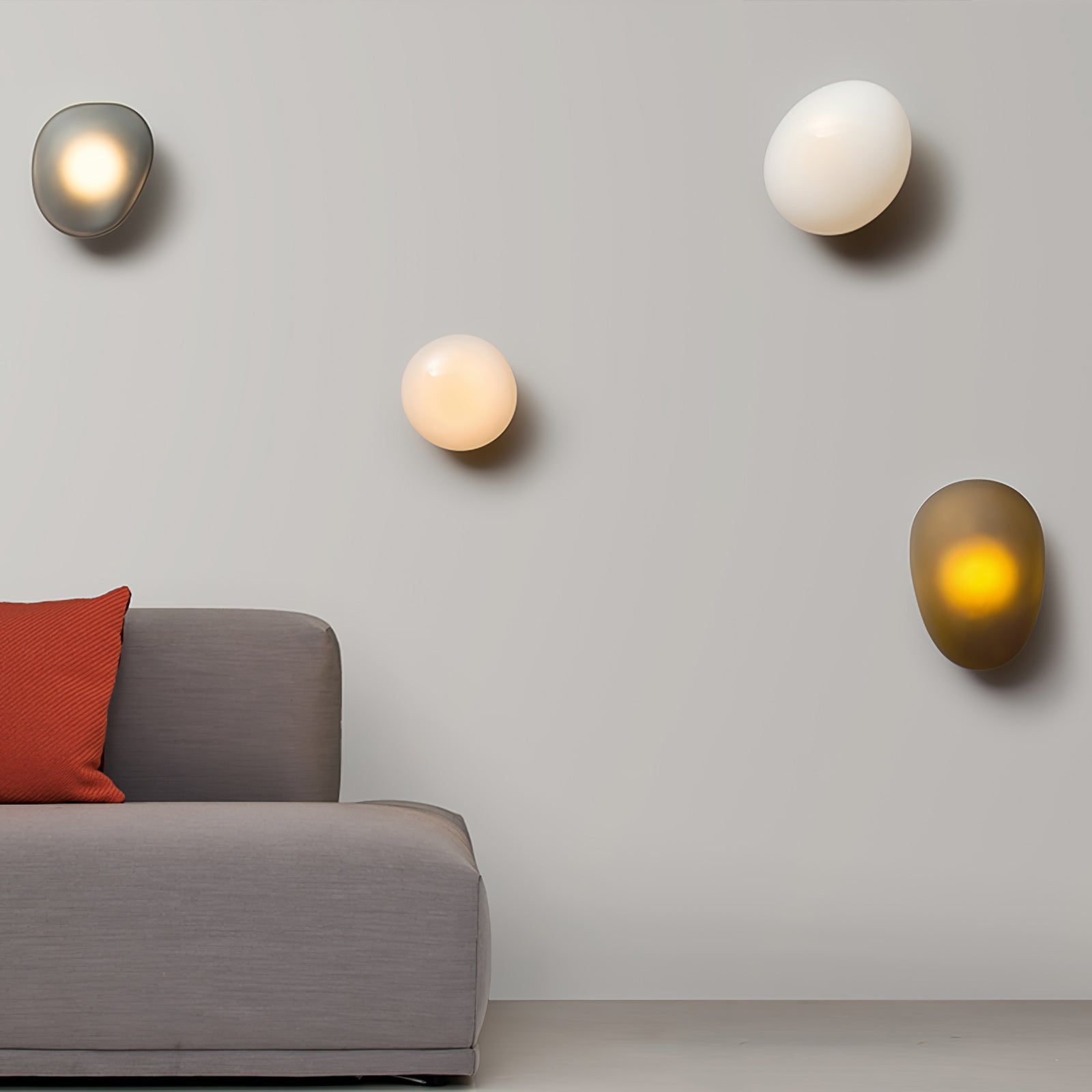 Pebble glass wall lamp lit warmly against a neutral wall