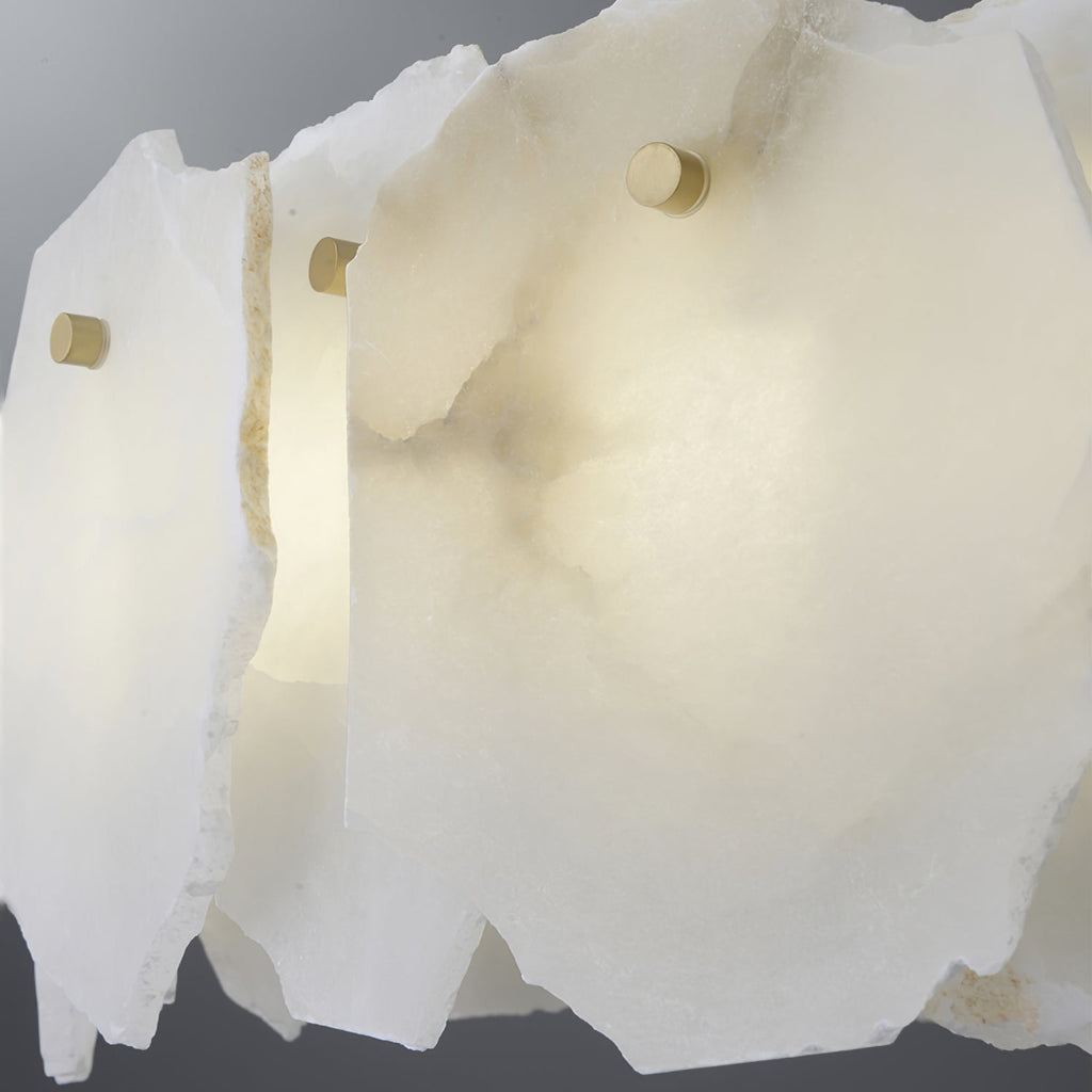 Macro of the alabaster plates, their veining and rough cut edges caught by a small brass pin