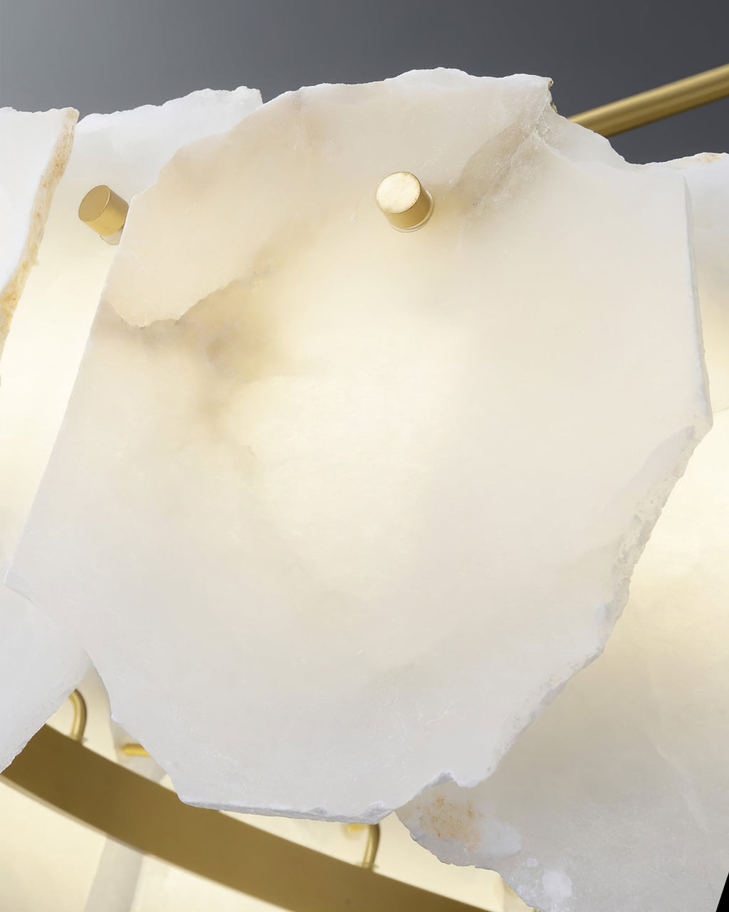 Close-up of one alabaster plate fixed by a brass pin, with the brass support ring below