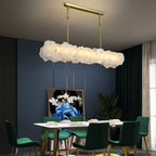 Linear Burton chandelier over a rectangular dining table set with green velvet chairs