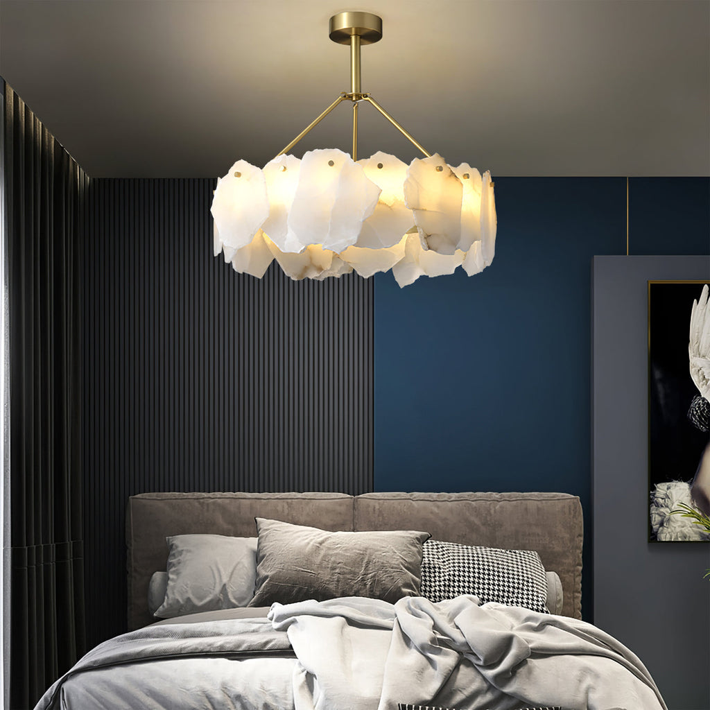 Burton chandelier glowing above a bed in a navy and charcoal bedroom
