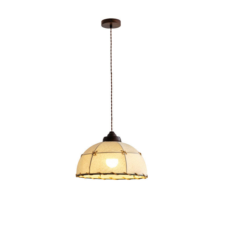 Product view of this Clérachic pendant showing its full cord, turned wood cap, and quilted rope-trimmed shade, lit.