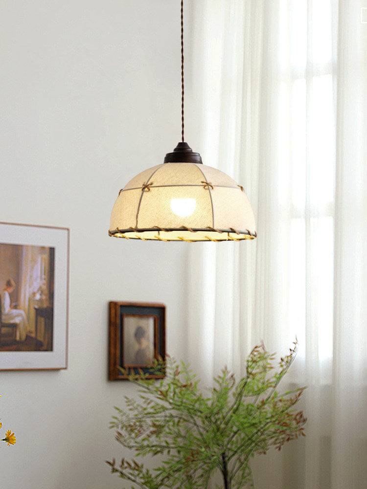 Near sheer curtains and a framed print, this Clérachic pendant's quilted shade casts a warm glow.