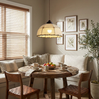 In a breakfast nook with a gallery wall and window blinds, this Clérachic pendant lights a round wood table.