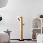 Clérachic branching floor lamp with the bulb off, a hint of greenery at the frame edge beside the shelf and cream ottoman.