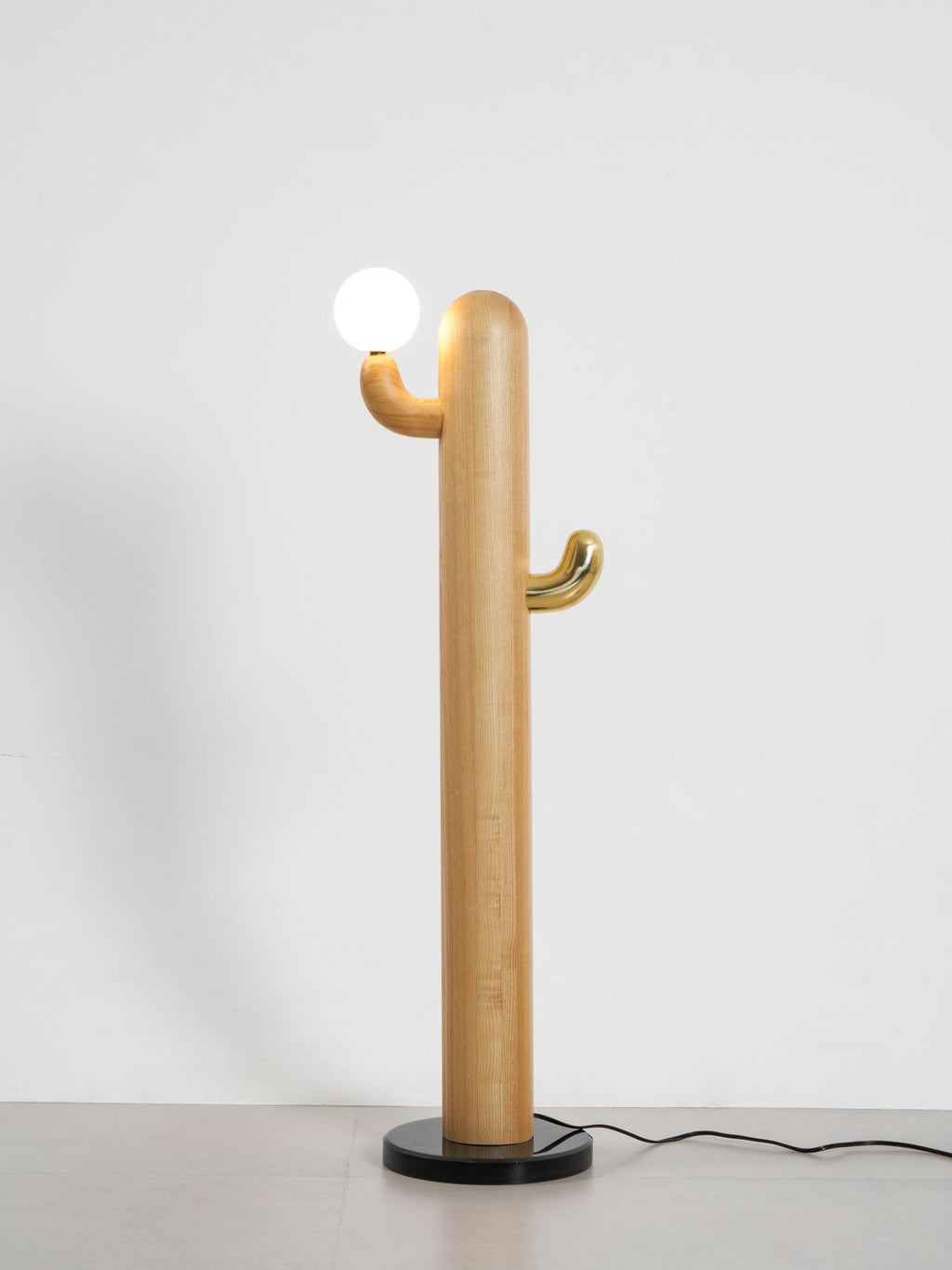 Pale-wood Clérachic floor lamp with a lit glass orb, full length on a grey studio background with the cord visible.