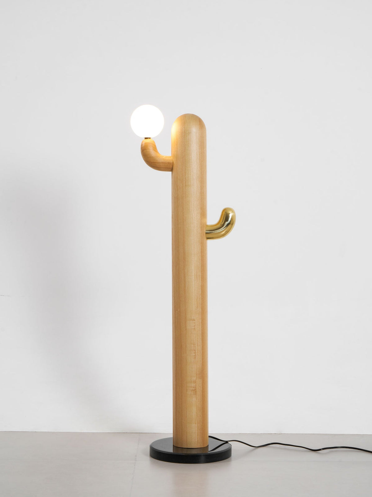 Pale-wood Clérachic floor lamp with a lit glass orb, full length on a grey studio background with the cord visible.