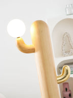 Close-up of a Clérachic floor lamp's pale wood arm reaching toward the glass orb, angled differently than nearby frames.