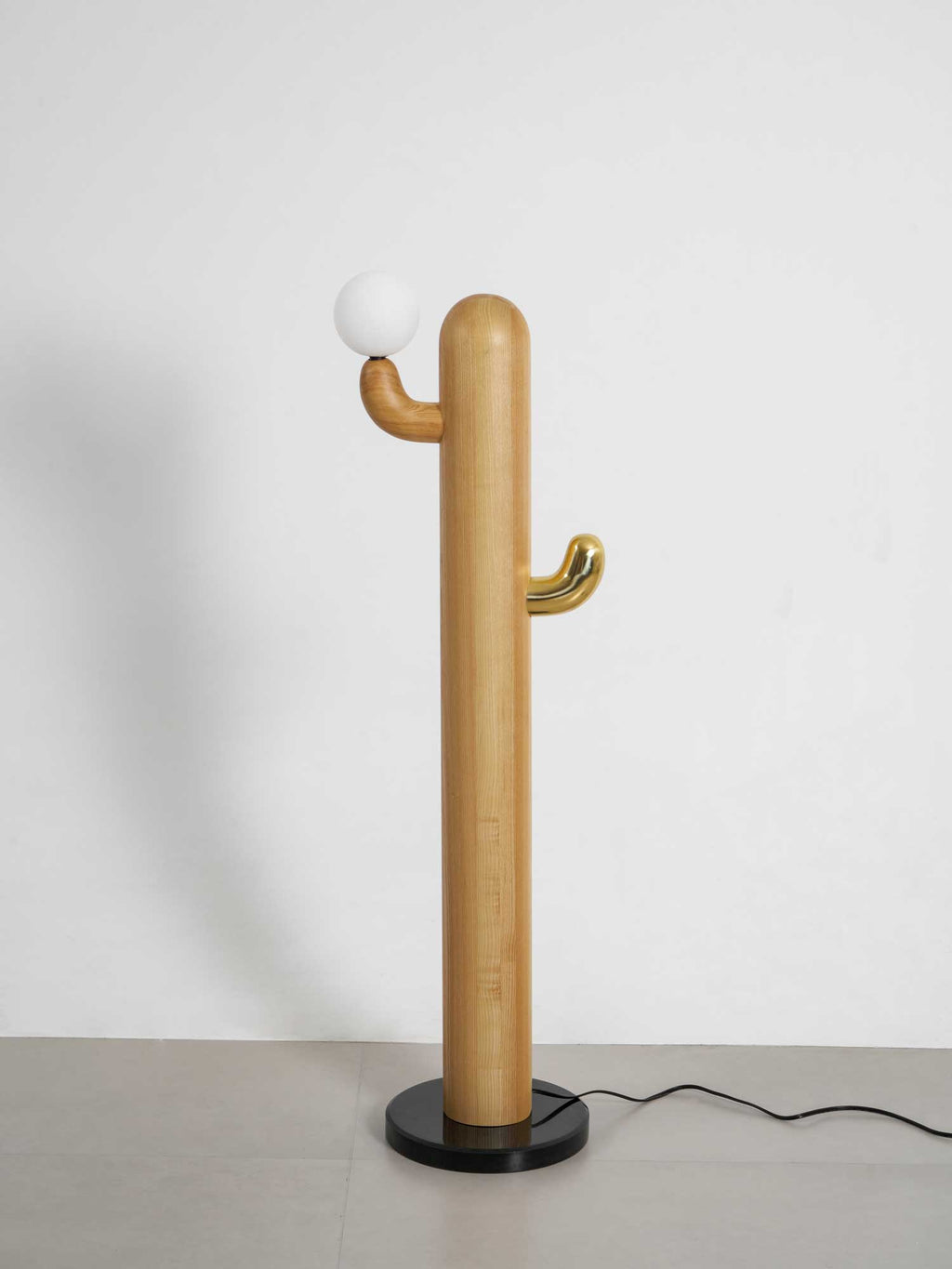 Pale-wood Clérachic floor lamp with a lit glass orb, shown full length on a plain grey studio background.