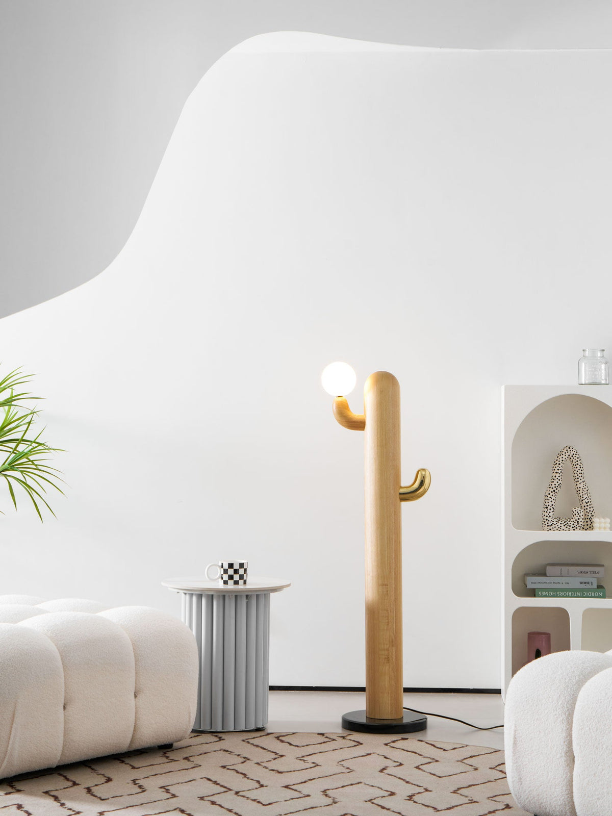 Clérachic curved wood floor lamp with its bulb unlit, a leafy plant edging into frame beside the cream ottoman and patterned rug.