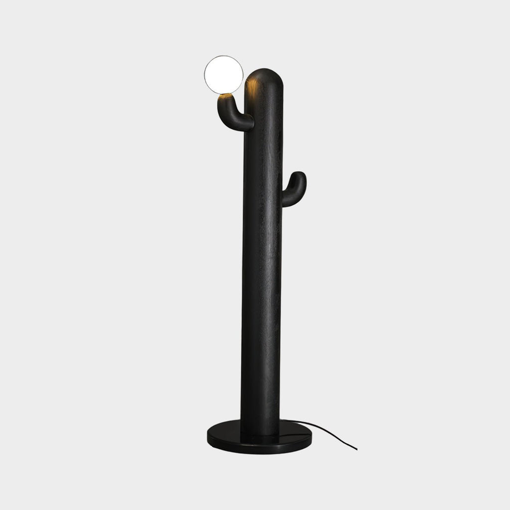 Black-finished Clérachic floor lamp with a lit glass orb, photographed against a plain grey studio background.