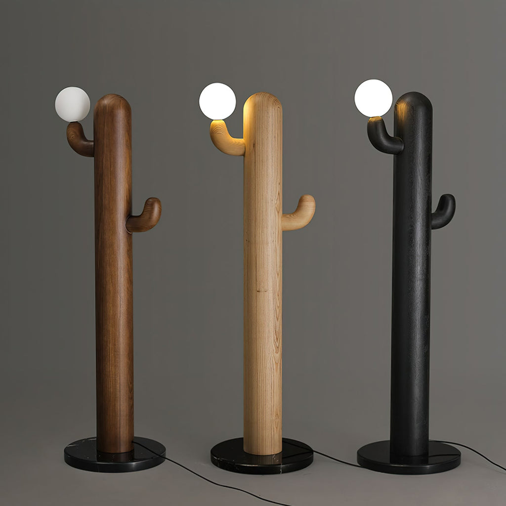 Three Clérachic floor lamps in walnut, pale wood and black finishes stand lit together on a grey studio backdrop.