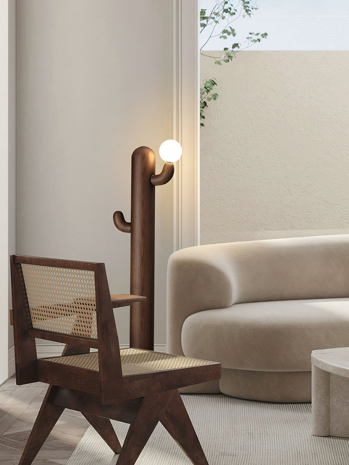 Dark wood Clérachic floor lamp glows beside a cane-seated armchair and a curved cream sofa near a sheer curtain.