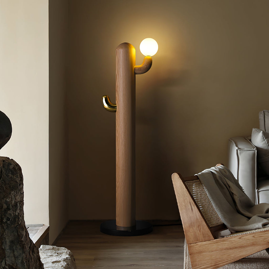 Wood-bodied Clérachic floor lamp lit beside a rattan lounger in a warm, olive-toned room corner with a rock ornament.