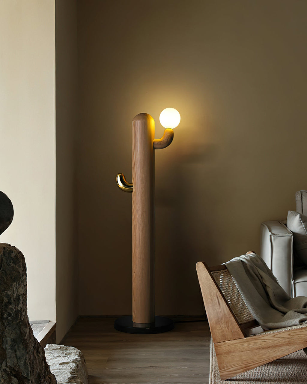 Walnut-toned Clérachic floor lamp glows in a dim room corner beside a rattan lounger, cropped close on the fixture.