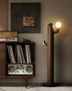 Walnut-finished Clérachic floor lamp glows near a record cabinet with vinyl albums and a vintage radio.