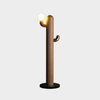 Medium wood-toned Clérachic floor lamp with a lit glass orb, photographed against a plain grey studio background.