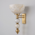 This Clérachic sconce in brushed brass shows its upward alabaster bowl stacked above two alabaster spheres.